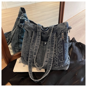 Detail of vintage denim tote bag showing metal side zipper and front snap button pocket