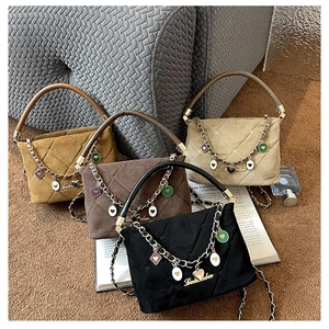 Detail of mini quilted handbags with chain straps and colorful heart charms in various colors