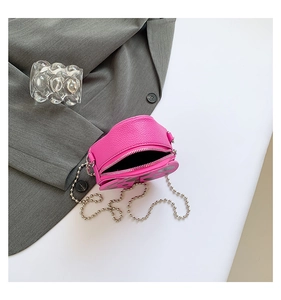Detail of pink heart-shaped crossbody bag with lychee texture and silver bead chain