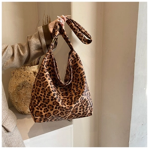 Large leopard print tote bag with wide shoulder strap shown in a minimalist home setting