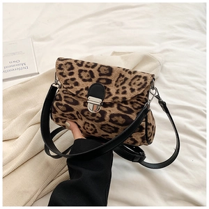 Detailed view of leopard print crossbody bag with silver buckle and black leather strap