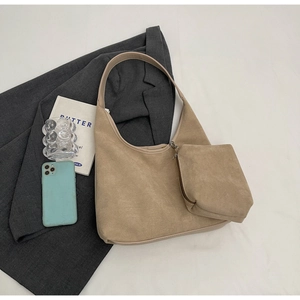 Détail du grand sac hobo en daim beige avec une petite pochette zippée assortie sur veste