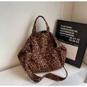 Detail view of leopard print canvas tote bag with wide shoulder strap and sturdy handles