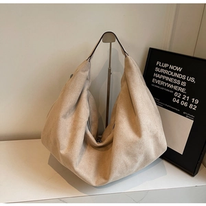 Detail view of large beige suede hobo shoulder bag with soft drape and metal zipper