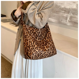 Detail of leopard print tote bag featuring a matching wide shoulder strap and knotted handle