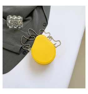 Detail view of yellow fruit-shaped mini crossbody bag with pebble leather and silver chain