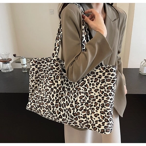 Detailed view of large leopard print tote bag styled with a professional khaki blazer