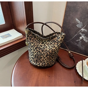 Detailed macro shot of leopard print tote bag with brown straps and golden rose charm