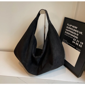 Detail of minimalist black oversized hobo bag with a premium matte suede texture finish
