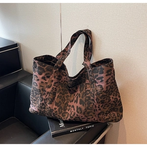 Detailed view of the wide shoulder straps and durable leopard print fabric on a tote bag