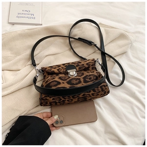 Detailed view of mini leopard print crossbody bag with silver buckle and leather strap