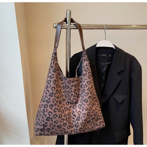 Sac fourre-tout en toile léopard suspendu près d'une veste pour un look décontracté