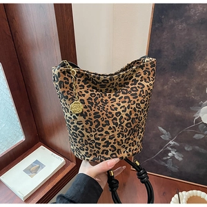 Detailed close-up of leopard print tote bag with gold flower charm and knotted black handle