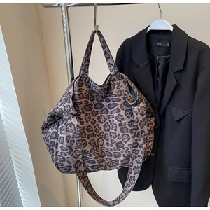 Detail of leopard print canvas tote bag featuring a wide shoulder strap and large capacity
