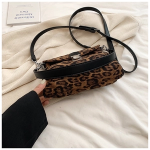 Close-up of leopard print crossbody bag with silver buckle and black leather strap