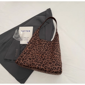 Gros plan du sac bandoulière léopard sur un costume gris avec détails de texture