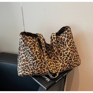 Detailed close-up of large leopard print tote bag texture and reinforced double handles
