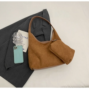 Détail du sac hobo en daim caramel avec pochette assortie et bandoulière en cuir