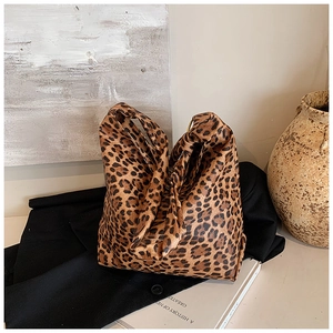Detail of leopard print tote bag featuring a unique circular metal handle design