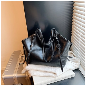 Detail view of black PU leather tote bag with adjustable silver buckles and straps