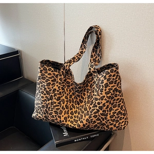 Detail view of leopard print tote bag with durable canvas straps on a leather seat