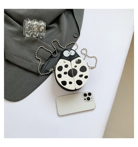 Detailed close-up of a ladybug shoulder bag with litchi texture and metal chain