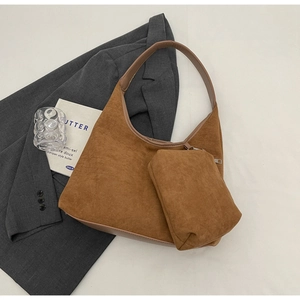 Détail du sac hobo en daim marron vintage avec pochette assortie sur une veste grise