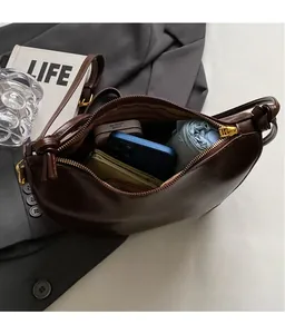 Deep brown crescent shoulder bag interior showing large storage capacity and zipper detail