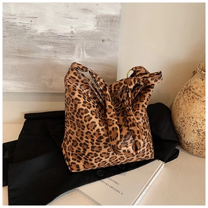 Close-up of leopard print canvas tote bag featuring metallic gold ring hardware