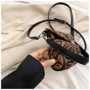 Close-up of small leopard print crossbody bag with silver buckle and textured fabric
