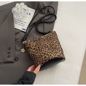 Detail of leopard print canvas tote with leather base and gold camellia charm