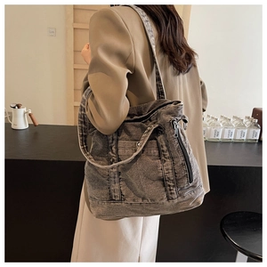 Detail of grey washed denim tote bag showing sturdy double stitching and metal zipper
