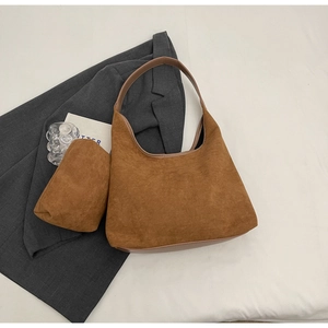 Gros plan détaillé du sac bandoulière en daim marron avec sa pochette zippée assortie