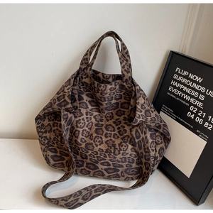 Detailed close-up of large leopard print tote bag showing canvas texture and dual straps