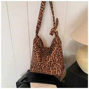 Detail of a leopard print canvas tote bag featuring a stylish knotted shoulder strap detail