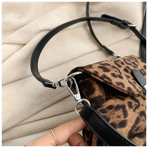 Close-up of leopard print velvet fabric with silver metal clasp and black leather strap