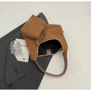 Détail d'un grand sac cabas en daim camel avec petit porte-monnaie sur veste grise