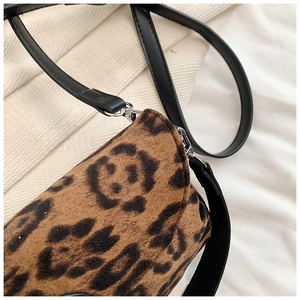 Detailed view of leopard print texture and silver metal hardware on a shoulder bag