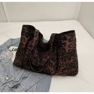 Detail of leopard print canvas tote bag laid on denim jacket for stylish daily commute