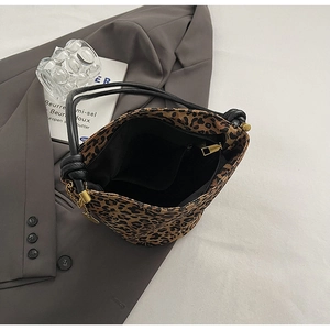 Detail view of leopard print tote bag interior with inner pocket and golden zipper closure