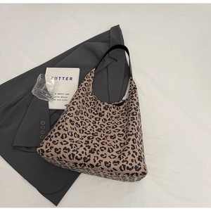 Gros plan d'un sac cabas en toile à imprimé léopard avec des anses en cuir noir élégantes