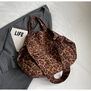 Detailed view of large leopard print tote bag with wide strap on minimalist background