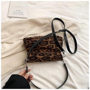 Detail of leopard print crossbody bag with soft faux fur texture and slim black leather strap