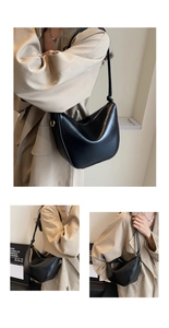 Detail view of black crescent shoulder bag with golden D-ring and smooth faux leather
