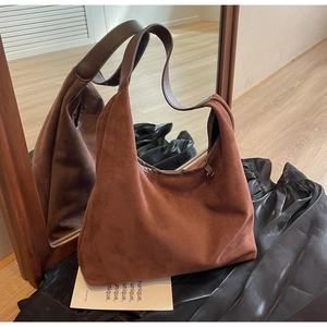Gros plan du sac en daim marron montrant sa texture souple et sa grande capacité