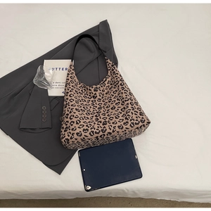 Mise à plat d'un grand sac fourre-tout léopard avec bandoulière, tablette et blazer