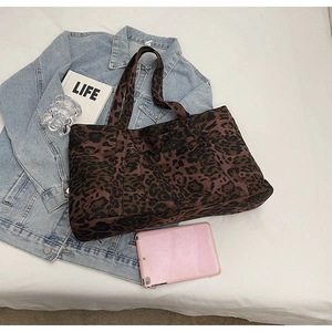 Macro detail of high-capacity leopard print tote bag fabric with matching wide shoulder strap
