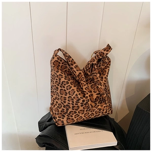Close-up of leopard print canvas hobo bag texture and wide shoulder strap detail