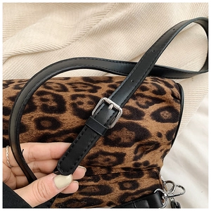 Detail of leopard print crossbody bag featuring adjustable black leather shoulder strap