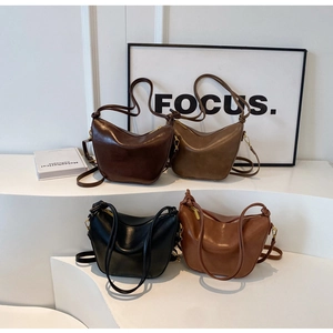 Detail view of four minimalist hobo bags in coffee, khaki, black and brown colors
